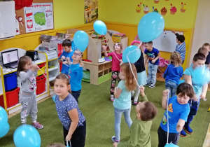 Dzieci bawią się niebieskimi balonami